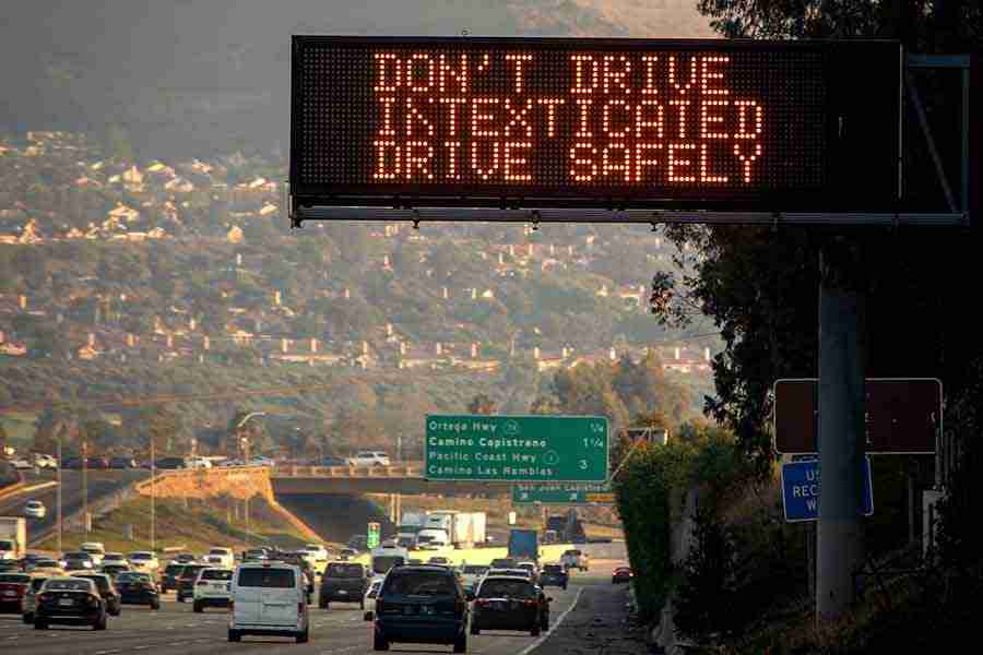 Photo of highway sign reading "Don't Drive Intexticated"